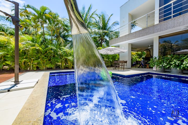 Piscina com cascata em meio ao jardim